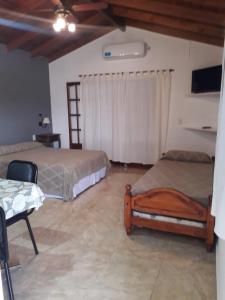 a bedroom with two beds and a table and a window at Departamentos Algarrobo in Arroyo de Los Patos