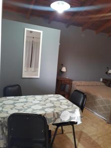 a bedroom with a bed and a table and chairs at Departamentos Algarrobo in Arroyo de Los Patos