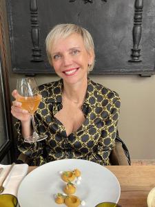 a woman sitting at a table with a glass of wine at New ! VUE PETITE VENISE-PLACE TO BE - PARKING in Colmar +21 photos