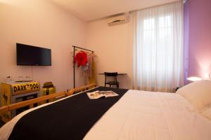 a bedroom with a large bed with a tv on the wall at Albergo Giardino in Cernobbio