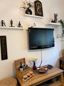 a living room with a flat screen tv on a wall at Camurichico in Figueira da Foz