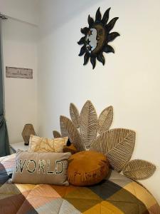 a clock on a wall above a bed with pillows at Camurichico in Figueira da Foz