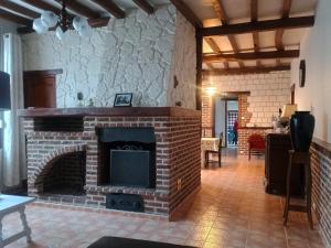 a living room with a brick fireplace in a room at demeure à la campagne in Conchy-sur-Canche