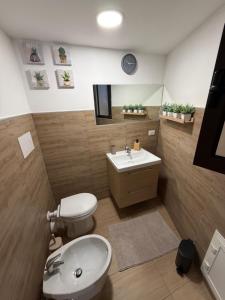 a bathroom with a white toilet and a sink at Casetta Villabate in Villabate