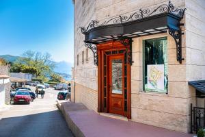 a building with a wooden door on the side of a street at Castello Mare Residence in Herceg-Novi