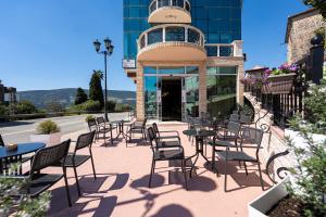 a group of tables and chairs in front of a building at Castello Mare Residence in Herceg-Novi