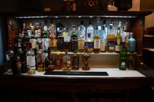 a shelf filled with lots of bottles of alcohol at Achness Hotel in Lairg