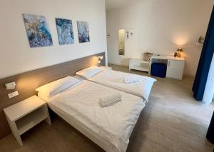 a bedroom with a large white bed in a room at Hotel Roma Aparthotel in Malcesine +72 photos