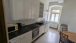 a kitchen with white cabinets and a sink and a table at Altstadthaus in Arnsberg +7 photos