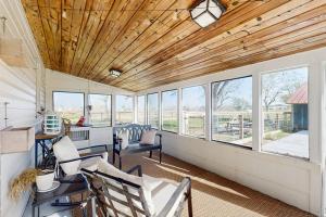 a living room with a wooden ceiling and windows at R&R Acres in Aransas Pass