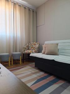 a bedroom with a bed and a chair at Studio chamorso - Cama Queen - AC - Garagem in Rondonópolis