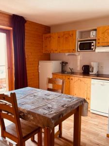 a kitchen with a wooden table and a table and chairs at studio Nivéole 303 in Chamrousse