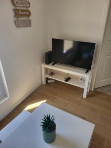 a living room with a flat screen tv on a stand at Appartement T2 - Sète centre ville - A deux pas des Halles in Sète