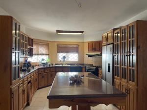 a large kitchen with wooden cabinets and a large island at Bright Bay Garden Suite in Montego Bay