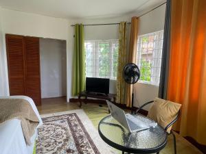 a living room with a laptop on a glass table at Bright Bay Garden Suite in Montego Bay