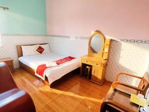 a small bedroom with a bed and a mirror at Mimosa 5 Hotel - Phan Rang in Bắc Sớn