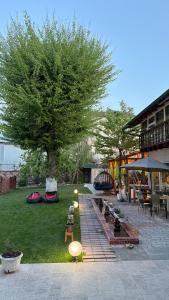 a garden with a tree and a table and chairs at Eco House in Osh
