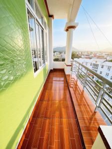 a balcony with green and wooden floors and windows at Mimosa 5 Hotel - Phan Rang in Bắc Sớn