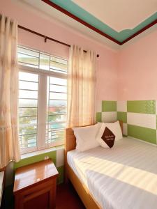 a bedroom with two beds and a window at Mimosa 5 Hotel - Phan Rang in Bắc Sớn
