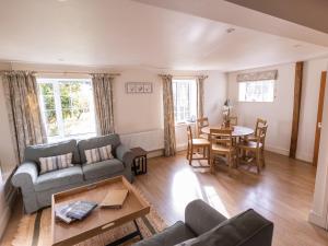 a living room with a couch and a table at Stable Cottage in Lechlade