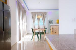 a dining room table with green chairs in a kitchen at Luxury Comfort Villa in Punta Cana