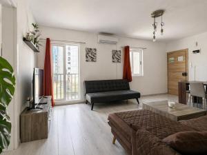 a living room with a couch and a table at Calypso 3 Large Stylish Apartment in Paceville with Mercury Tower View Ideal for Groups in St. Julianʼs