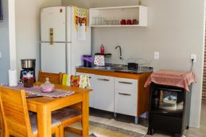 a kitchen with a table and a refrigerator at Kitnet confortável in Foz do Iguaçu