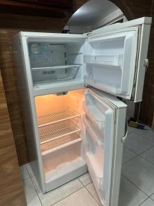 an open refrigerator with its door open and its contents at Departamento con parqueadero céntrico in Baños