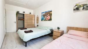 two beds in a room with white walls at Calypso 3 Large Stylish Apartment in Paceville with Mercury Tower View Ideal for Groups in St. Julianʼs
