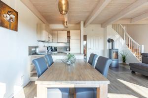 a kitchen and dining room with a wooden table and chairs at Ferienhaus Basstölpel in Dagebüll