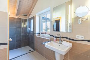 a bathroom with a sink and a shower and a mirror at Ferienhaus Basstölpel in Dagebüll +26 photos
