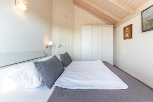 a bedroom with a large white bed in a room at Ferienhaus Basstölpel in Dagebüll
