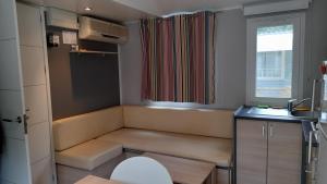 a small kitchen with a bench and a window at Mobil Home AGDE Hérault in Agde