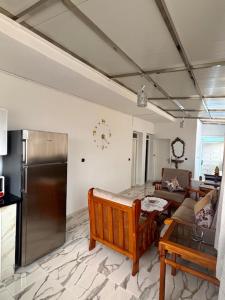 a kitchen with a refrigerator and a living room at Appartement Ajdir in Al Hoceïma
