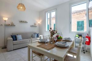 a dining room and living room with a table and chairs at NURAS - Casa Aurelia square view old town in Alghero