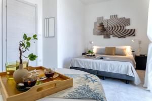 a room with two beds and a table with a tray at NURAS - Casa Aurelia square view old town in Alghero