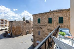 a balcony with a view of an old building at NURAS - Casa Aurelia square view old town in Alghero