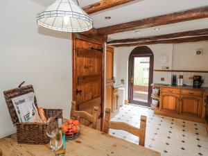 a kitchen with a wooden table and a dining room at The Haybarn in Lichfield