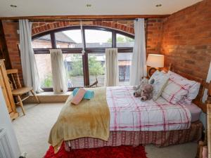 a bedroom with a bed with a teddy bear on it at The Haybarn in Lichfield