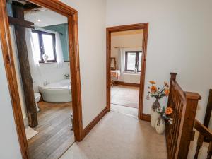 a bathroom with a tub and a toilet and a mirror at The Haybarn in Lichfield +43 photos