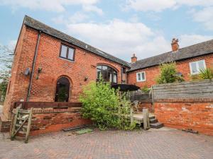 an old brick house with a brick wall at The Haybarn in Lichfield