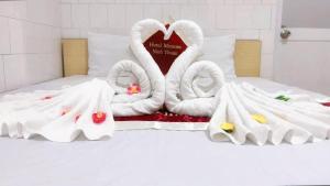 two swans made out of towels on a bed at Mimosa 6 Hotel - Phan Rang in Phan Rang–Tháp Chàm