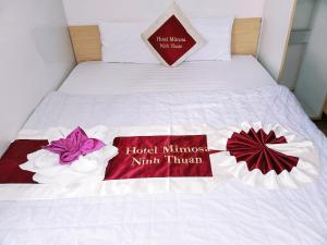 a bed with two red and white towels on it at Mimosa 6 Hotel - Phan Rang in Phan Rang–Tháp Chàm +4 photos