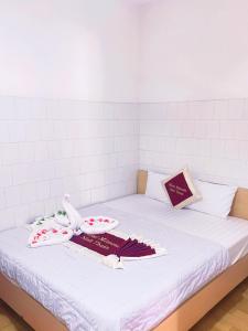 a white bed with some items on top of it at Mimosa 6 Hotel - Phan Rang in Phan Rang–Tháp Chàm