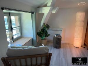 a living room with a couch and a window at Appartement cocon de charme, Domaine Cornevent Lyon, parc & piscine in Vernaison