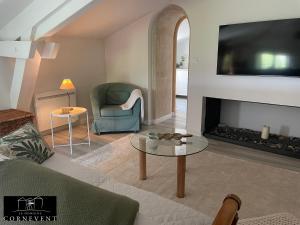 a living room with a couch and a fireplace at Appartement cocon de charme, Domaine Cornevent Lyon, parc & piscine in Vernaison