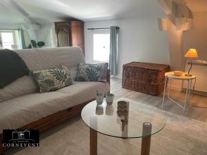 a living room with a couch and a glass table at Appartement cocon de charme, Domaine Cornevent Lyon, parc & piscine in Vernaison