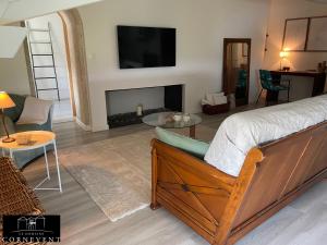 a bedroom with a bed and a living room with a fireplace at Appartement cocon de charme, Domaine Cornevent Lyon, parc & piscine in Vernaison