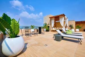 a patio with chairs and a vase with a plant at Vintano Hotel in Lagos