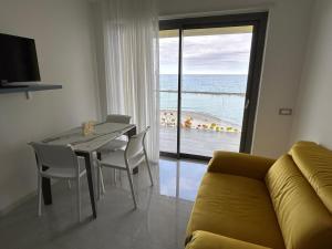 a living room with a table and a view of the ocean at Yellow Dream B&B in Torre Melissa